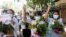缅甸妇女在仰光手捧鲜花参加反对军事政变的抗议活动。（2021年4月13日）