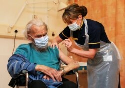 FILE - A man receives the Oxford University/AstraZeneca COVID-19 vaccine at the Churchill Hospital in Oxford, Britain, Jan. 4, 2021.