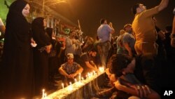 Des femmes allument des bougies pour rendre hommage aux victimes de l'attentat de Bagdad dans le quartier de Karada, Irak, le 4 juillet 2016.