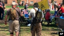 FILE - Two men carrying semiautomatic rifles attend a gun rights rally outside the state capitol in Dover, Delaware, April 14, 2018. 