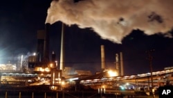 Asap mengepul dari cerobong asap di pabrik BlueScope Steel di Port Kembla, selatan Sydney, Australia. Parlemen Australia, Kamis (8/9), meloloskan RUU peningkatan target pemerintah untuk mengurangi emisi gas rumah kaca. (Foto: AP)