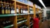 A staff checks on bottles of wine at a supermarket in Shanghai, China, June 2, 2016. 