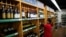 A staff checks on bottles of wine at a supermarket in Shanghai, China, June 2, 2016.