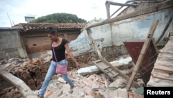 Peregrina, 26, an indigenous Zapotec transgender woman also know as muxe, walks on the debris of her house destroyed after an earthquake that struck on the southern coast of Mexico late Thursday, in Juchitan. 