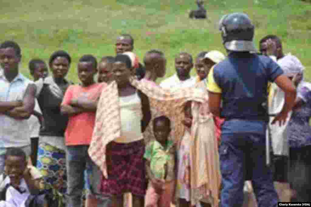 Des gens sont rassemblés à l'exterieur, lors du procès des rebelles présumés ADF, à Beni, RDC, le 24 août 2016. (VOA/Charly Kasereka)