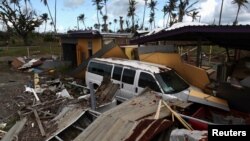 A car is partially buried under the remains of a building, after Hurricane Maria hit the island in September, in Humacao, Puerto Rico, Jan. 25, 2018.