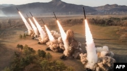 This picture taken on March 18, 2024 and released from North Korea's official Korean Central News Agency (KCNA) on March 19, 2024 shows North Korea's Western Region Artillery Unit's ultra-large rocket salvo firing drill.