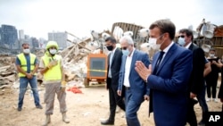 Rais wa Ufaransa Emmanuel Macron, kulia, akitembelea eneo liloathiriwa na mlipuko katika bandari ya Beirut , Lebanon, Alhamisi Agosti 6, 2020.