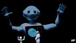 FILE - SoftBank Corp. CEO Masayoshi Son speaks with the company's companion robot Pepper during a press conference in Maihama, near Tokyo, June 18, 2015. 