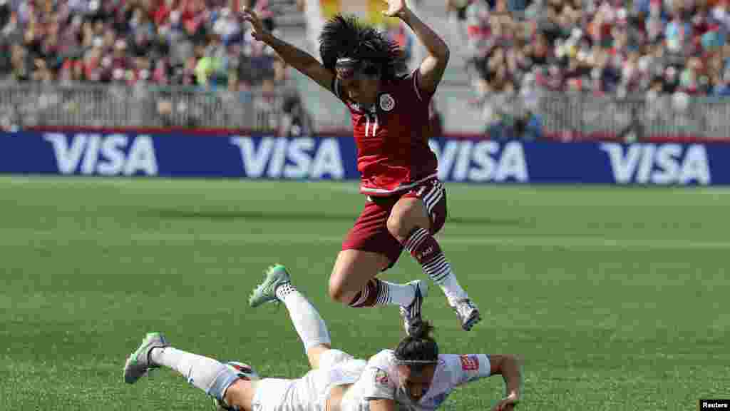 Monica Ocampo, attaquante du Mexique (11), saute et évite un contact avec la défense Lucy Bronze (12) au cours de la première mi-temps d'un match de football à la Coupe du Monde de la FIFA féminine au stade de Moncton au Nouveau-Brunswick, Canada, le 13 Juin 2015. (Photo de Matt Kryger - USA Today)