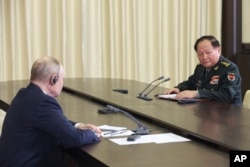 Presiden Rusia Vladimir Putin, (kiri) berbicara dengan Jenderal Zhang Youxia, Wakil Ketua Komisi Militer Pusat China, dalam pertemuan di luar Moskow, 8 November 2023. (Foto Kremlin via AP)