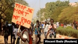 Un manifestant tient une pancarte indiquant "Trop de morts, M. Rock", lors d'une manifestation appelant à la démission du président du Burkina Faso, Roch Kabore, et au départ des forces françaises qui patrouillent dans le pays, à Ouagadougou, au Burkina Faso, le 27 novembre 2021.