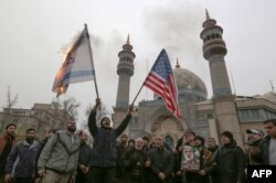 FILE - Iranians burn an Israeli and a U.S. flag during an anti-U.S. protest in the capital Tehran, Jan. 4, 2020, over the killings of Iranian military commander Qassem Soleimani and Iraqi paramilitary chief Abu Mahdi al-Muhandis.