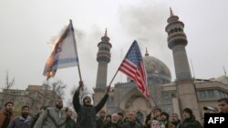 Iranians burn an Israeli and a U.S. flag during an anti-U.S. protest in the capital Tehran, Jan. 4, 2020, over the killings of Iranian military commander Qasem Soleimani and Iraqi paramilitary chief Abu Mahdi al-Muhandis.