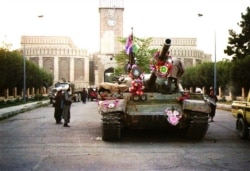 FILE - Tanks manned by Taliban fighters and decorated with flowers are seen in front of the the presidential palace in Kabul, Afghanistan, Sept. 28, 1996.