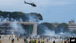 FILE - Supporters of Brazil's former President Jair Bolsonaro clash with police as they storm the Planalto presidential palace, the official workplace of the president, in Brasilia, Brazil, Jan. 8, 2023.