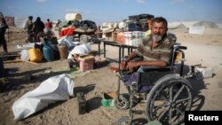 د فلسطينی کورنۍ په ويل چېیر ناست یو تن د خان یونس نه تګ کوي. اسرایل په سیمه کې فلسطینیانو ته د وتلو امر کړی دی
