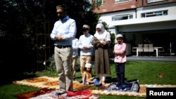 Keluarga Farood Ahmed melakukan salat Idul Fitri di halaman rumah mereka di London, Inggris Minggu (24/5). 