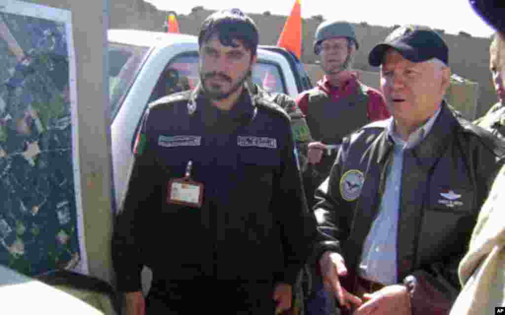 Secretary Gates asks a question during a briefing by the local police chief in Tabin