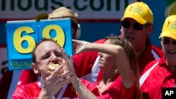 Joey Chestnut bersaing dalam dan menjuarai kontes tahunan Nathan’s Famous Hot Dog. New York, New York (foto: AP Photo/Mary Altaffer)