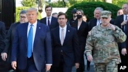 El secretario de Defensa, Mark Esper, en el centro, recorre la plaza Lafayette, junto al presidente Donald Trump y al jefe del Estado Mayor Conjunto, el general Mark Milley, minutos después de que el mandatario amenazara con activar al ejército.