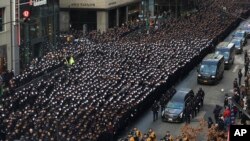 New York Police salute as a hearse carrying the casket of NYPD Officer Wilbert Mora is escorted down Fifth Avenue after his funeral service at St. Patrick&#39;s Cathedral in New York.&nbsp;Mora was shot along with Officer Jason Rivera on Jan. 22 while responding to a call about a domestic argument in an apartment.