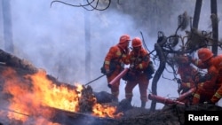 Firefighters work on extinguishing a forest fire that started near Xichang in Liangshan prefecture of Sichuan province, China March 31, 2020.