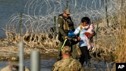 资料照片：移民在德克萨斯州伊格尔帕斯的美墨边境被巡逻人员拘留。（2024年1月3日）