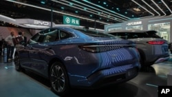 在北京举行的2026中国国际汽车展上，中国汽车制造商比亚迪(BYD)在零下温度的展区附近展示其电池充电技术，展区旁陈列着各类车型，参观者们正围观交谈。(2026年4月25日)