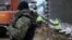 FILE - Workers build the first part of a wall intended to block migrants pushed by Belarus, in what the European Union calls a "hybrid attack," from crossing illegally into EU territory, in Tolcze, near Kuznica, Poland, on the border with Belarus, Jan. 27, 2022.