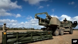 资料照片：美国陆军提供的照片显示，在澳大利亚昆士兰，美国陆军第17野战炮兵旅的军人准备把陆军战术导弹系统(ATACMS)填装入高机动性多管火箭系统(“海马斯”，HIMARS）。(2023年7月26日)