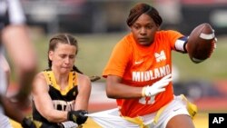 Ottawa defensive end Jennifer Anthony, left, tackles Midland's JaNasia Spand (11) during an NAIA flag football game in Ottawa, Kan., March 26, 2021. 