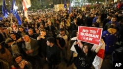 FILE - Protesters gather outside the parliament building in Tbilisi, Georgia, on April 15, 2024, to protest the "the Russian law," similar to a law that Russia uses to stigmatize independent news media and organizations seen as being at odds with the Kremlin.