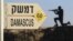 A sign showing the distances to Damascus and a cut out of a soldier are seen at an army post from the 1967 war at Mt. Bental in the Golan Heights, overlooking Syria, July 24, 2012.