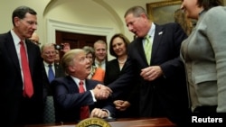 El presidente Donald Trump saluda a uno de los invitados a la Casa Blanca durante la firma de la orden ejecutiva sobre la preservación del agua.