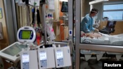 A critical care respiratory therapist works with a COVID-19 patient at Sarasota Memorial Hospital in Sarasota, Florida, February 11, 2021.