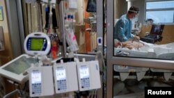 FILE - A critical care respiratory therapist works with a COVID-19 patient at Sarasota Memorial Hospital in Sarasota, Florida, February 11, 2021.