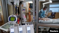 A critical care respiratory therapist works with a COVID-19 patient at Sarasota Memorial Hospital in Sarasota, Florida, February 11, 2021.