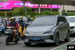 Sebuah kendaraan listrik melaju di jalan raya Jakarta, 5 Desember 2024. (BAY ISMOYO / AFP)