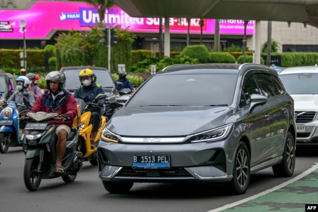 Sebuah kendaraan listrik melaju di jalan raya Jakarta, 5 Desember 2024. (BAY ISMOYO / AFP)