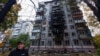 A resident stands in front of an apartment building damaged by a Russian drone strike, amid Russia's attack on Ukraine, in Kyiv, Ukraine October 30, 2024. 