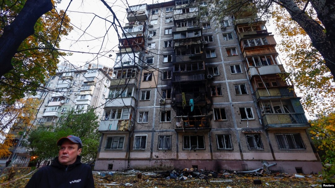 A resident stands in front of an apartment building damaged by a Russian drone strike, amid Russia's attack on Ukraine, in Kyiv, Ukraine October 30, 2024. 
