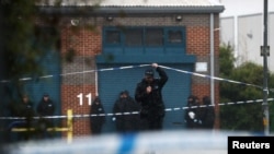 A police officer moves the tape inside the cordon, at the scene where bodies were discovered in a lorry container, in Grays, Essex, Britain, Oct. 24, 2019.