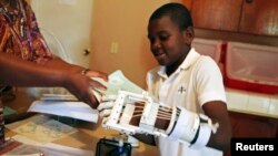 Stevenson Joseph, 12, learns to use a 3-D-printed prosthetic hand at the orphanage where he lives in Santo, near Port-au-Prince, Haiti, April 28, 2014.