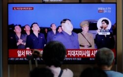 People watch a TV news program reporting about North Korea's firing projectiles with a file image of North Korean leader Kim Jong Un at the Seoul Railway Station in Seoul, South Korea, Aug. 16, 2019.