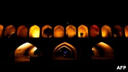 Iranians walk next to the "Si-o-Se Pol" bridge (33 Arches bridge), April 12, 2018, over the Zayandeh Rud river in Isfahan, which now runs dry because of water extraction before it reaches the city. The 295-meter-long bridge was completed in 1596 by an Iranian Safavid king, Shah Abbas the Great (Shah Abbas l).