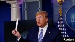 U.S. President Donald Trump shows a packaging containing a swab to be used for coronavirus disease (COVID-19) testing during the daily coronavirus task force briefing at the White House in Washington, U.S., April 19, 2020.