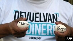 Un miembro del partido opositor LIBRE, sostiene dos huevos con el nombre de Marco Bográn, mientras que el exdirector de Inversión Estratégica de Honduras declara por cargos de malversación de fondos públicos, 5 de octubre 2020. 