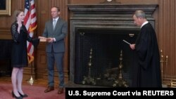 Ejmi Koni Beret polaže zakletvu kao sudija Vrhovnog suda pred predsedavjućim tog tela Džonom Robertsom, dok njen suprug Džesi Beret drži Bibliju u zgradi Vrhovnog suda u Vašingtonu (Foto: Reuters/Supreme Court).