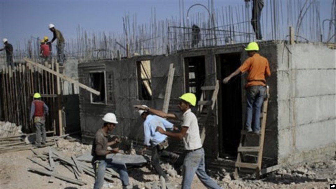 Palestinian men work on a construction site in the West Bank Jewish settlement of Kiryat Arba, near Hebron, 20 Oct 2010